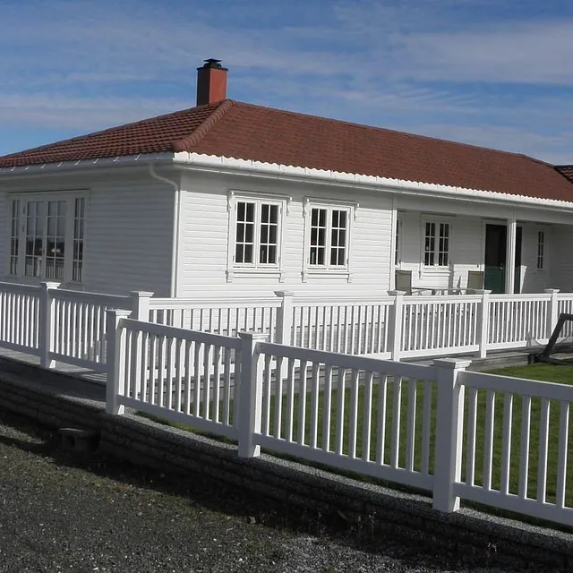 Hvitt stort hus med gjerde